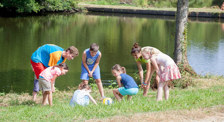 groupe d'enfants jouant au bord du lac