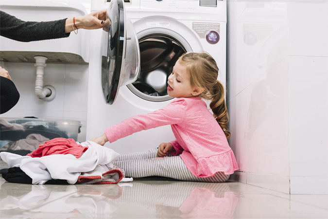 enfant près d'une machine à laver