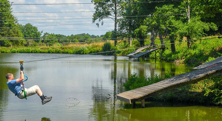 homme faisant de la tyrolienne au-dessus du lac